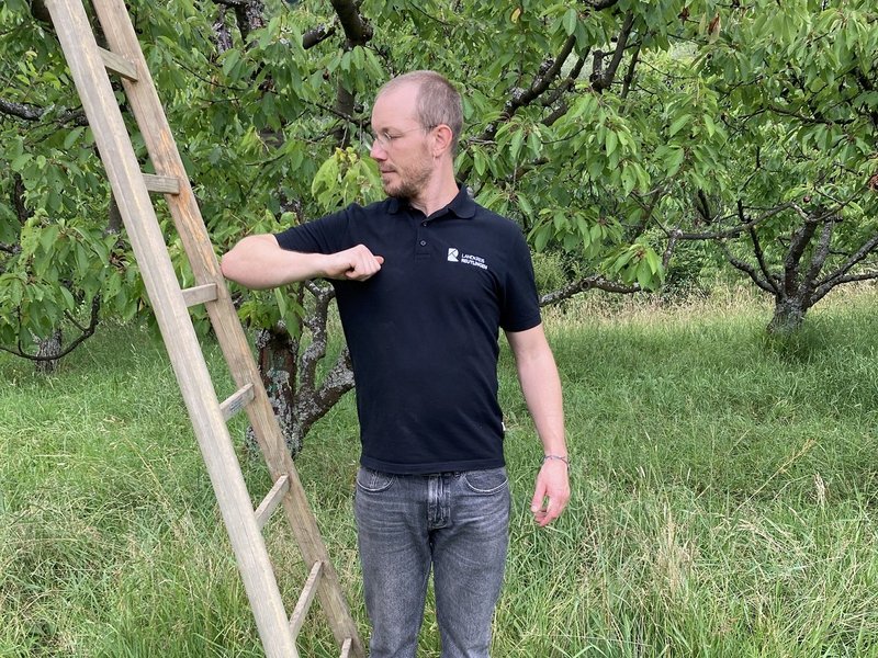 Simon Walch, Kreisfachberater für Obst- und Gartenbau des Landratsamtes Reutlingen, zeigt, wie die Ellbogenprobe bei Leitern aussieht. (Fotoquellen: Landratsamt Reutlingen)