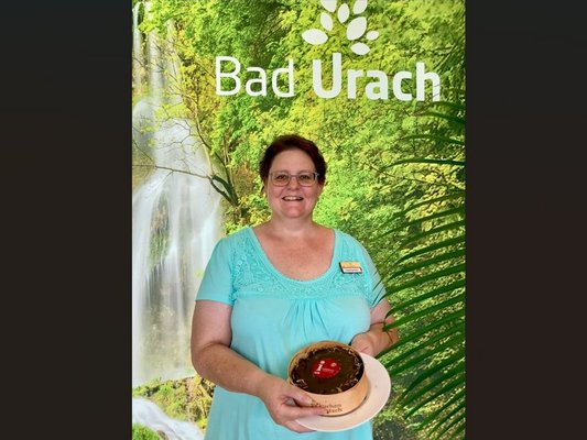 Tanja Eisenlohr von der Kurverwaltung Bad Urach mit dem Jubiläumskuchen des Deutschen Tourismusverbands | Credit: Bad Urach Tourismus